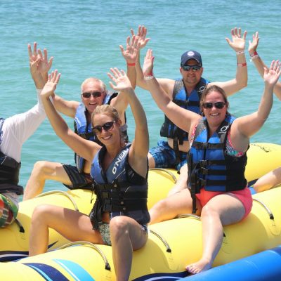 a group of people sitting next to a body of water