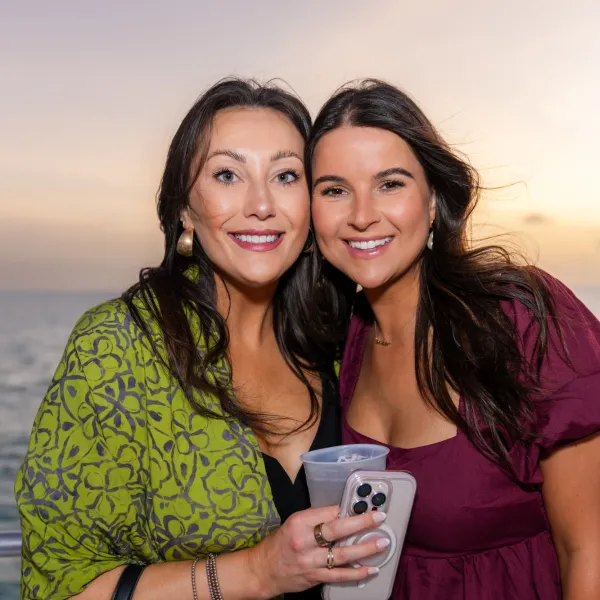 a person smiling next to a body of water