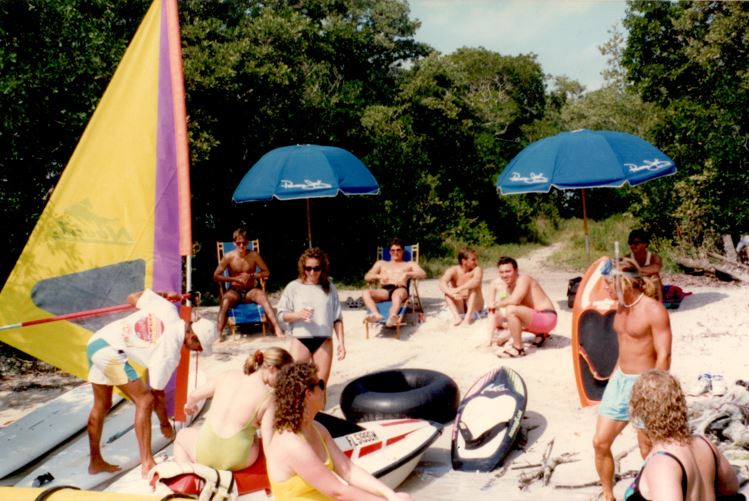 a group of people sitting around a dinner table umbrella