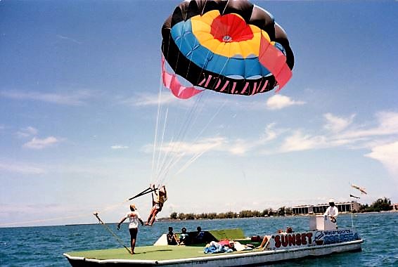 a group of people flying a kite in a large body of water