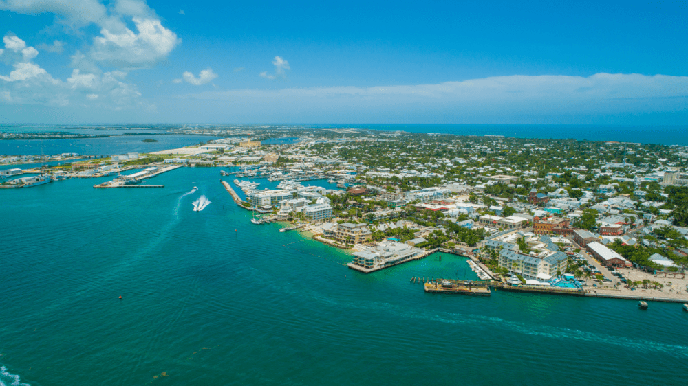 Aerial view of a coastal city with blue ocean and clear sky.