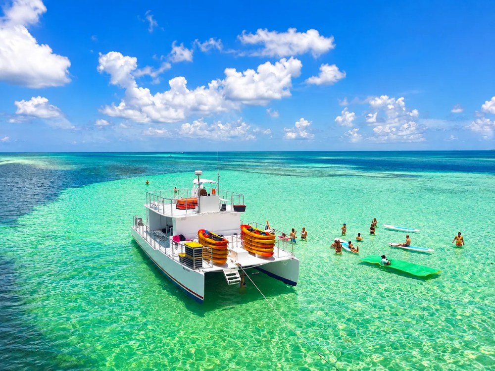 Key West sandbar trip with guests swimming, kayaking and paddleboarding in clear turquoise water